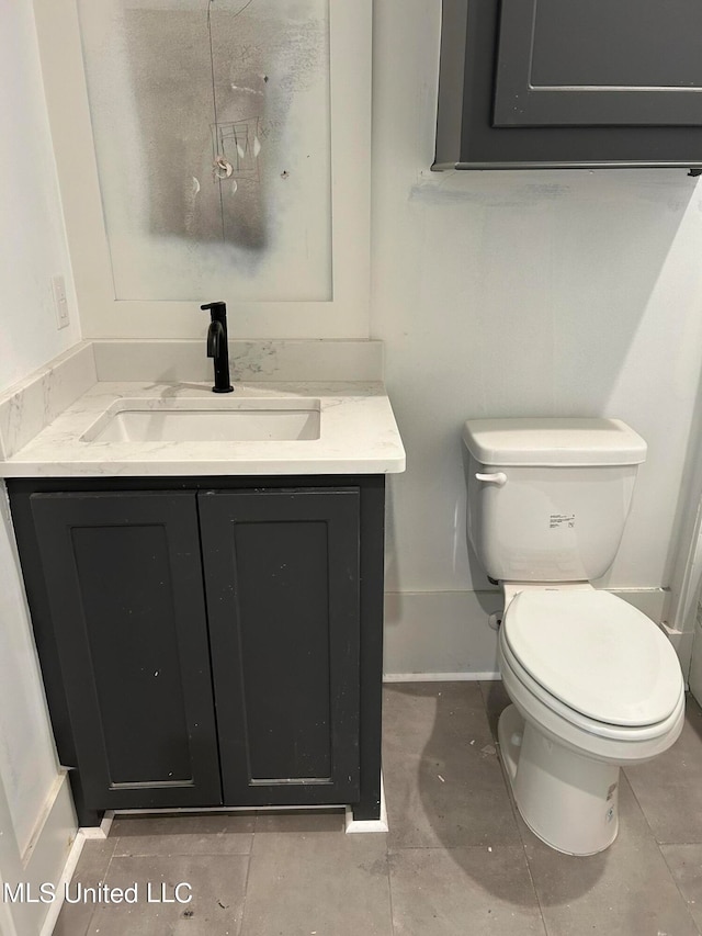 bathroom with tile patterned flooring, vanity, and toilet