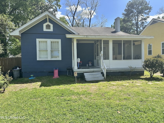 425 Downing St, Jackson, MS 39216 - rear view of house featuring crawl space, a chimney, fence, a yard, and a sunroom