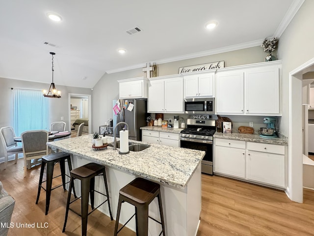 708 Silver Bnd, Pearl, MS 39208 - kitchen featuring appliances with stainless steel finishes, white cabinets, a breakfast bar area, crown molding, and a kitchen island with sink
