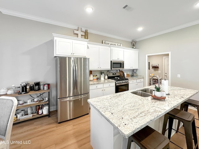 708 Silver Bnd, Pearl, MS 39208 - kitchen with appliances with stainless steel finishes, crown molding, a kitchen bar, white cabinetry, and light wood-style floors