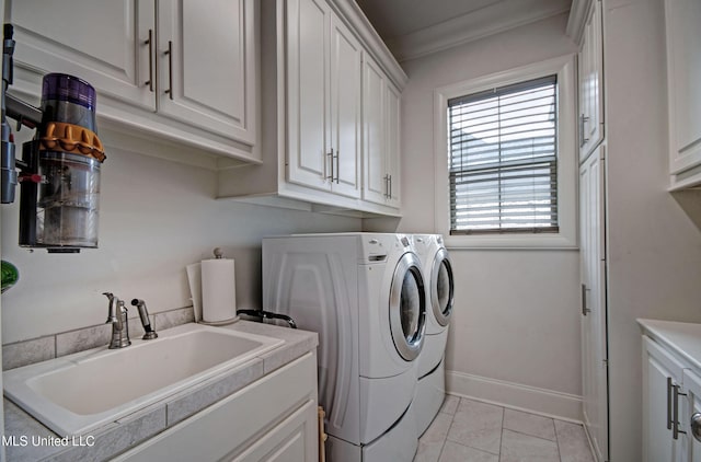 washroom with cabinet space, washing machine and dryer, light tile patterned floors, and baseboards