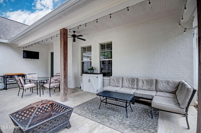 view of patio with an outdoor living space with a fire pit, ceiling fan, and outdoor dining space