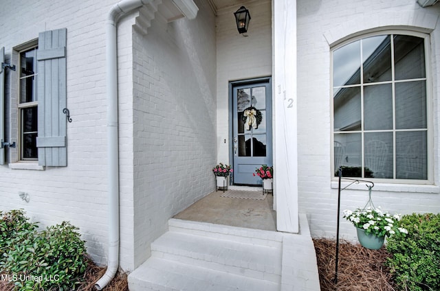 view of exterior entry featuring brick siding
