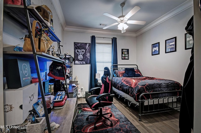 bedroom with wood finished floors, crown molding, and ceiling fan