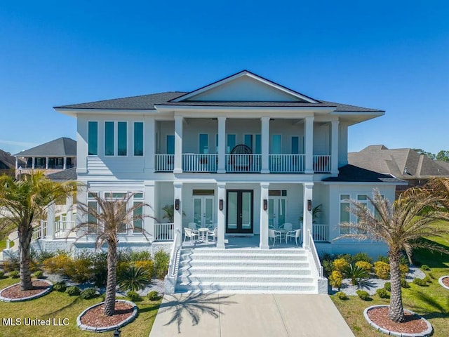 view of front of home featuring a patio, french doors, stairway, and a balcony