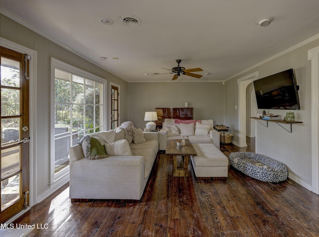 living room featuring dark hardwood / wood-style flooring, ornamental molding, and ceiling fan