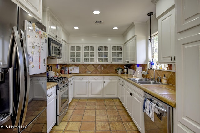 kitchen with stainless steel appliances, sink, hanging light fixtures, and white cabinets