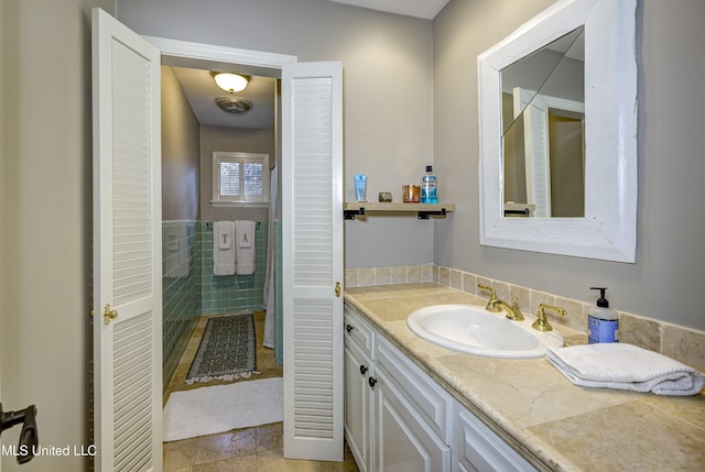 bathroom with tile patterned floors, vanity, and tile walls