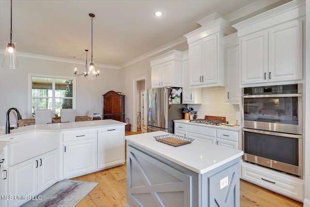 221 Lost Oak Ln, Brandon, MS 39047 - kitchen featuring stainless steel appliances, decorative backsplash, light countertops, white cabinets, and decorative light fixtures
