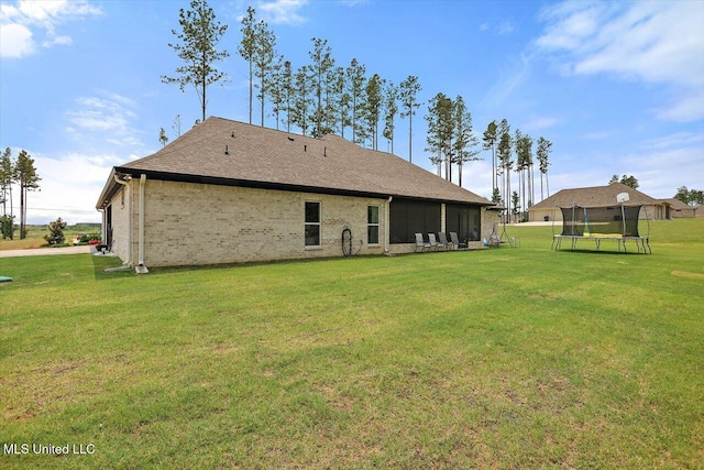 221 Lost Oak Ln, Brandon, MS 39047 - back of house featuring a trampoline, a yard, brick siding, and a sunroom