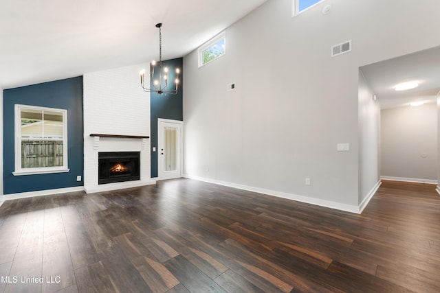 3106 Breezy Hill Ln, Ocean Springs, MS 39564 - unfurnished living room with high vaulted ceiling, dark wood-type flooring, a fireplace, and a chandelier