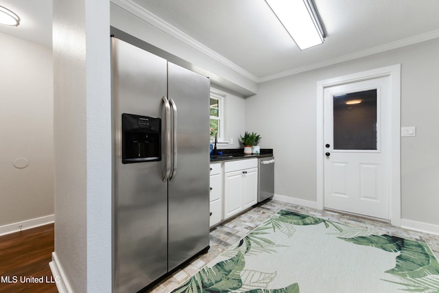 3106 Breezy Hill Ln, Ocean Springs, MS 39564 - kitchen featuring appliances with stainless steel finishes, ornamental molding, white cabinetry, dark countertops, and light wood-style floors