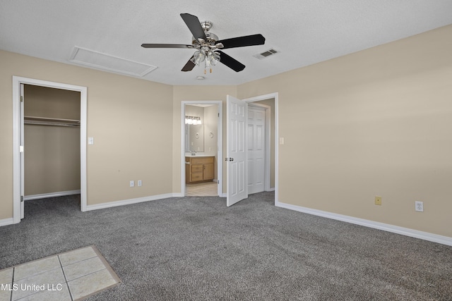 unfurnished bedroom with visible vents, carpet flooring, attic access, and baseboards