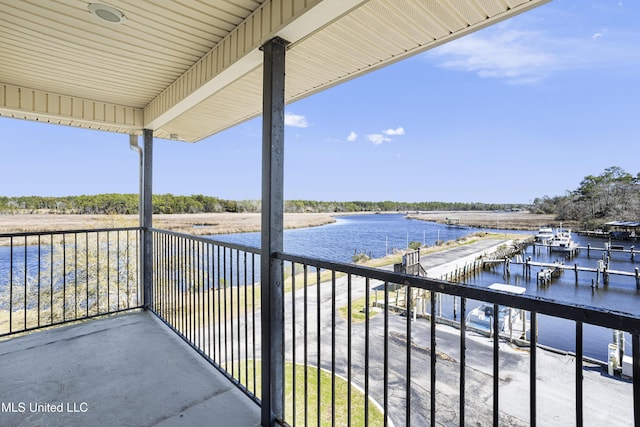 balcony with a water view and a dock