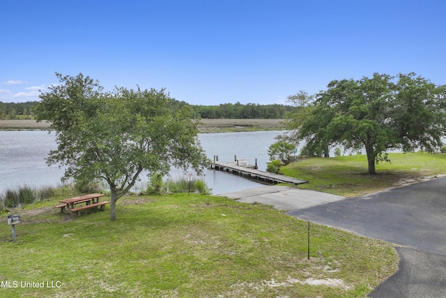 dock area with a yard and a water view