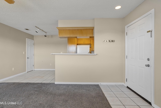 foyer with light tile patterned floors, visible vents, and a textured ceiling