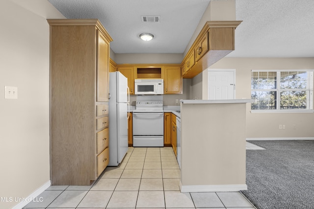 kitchen featuring visible vents, white appliances, a peninsula, light countertops, and light tile patterned floors