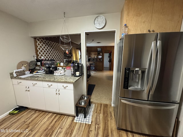 15708 Orleans Dr, Biloxi, MS 39532 - kitchen featuring stainless steel fridge, light wood-style floors, white cabinets, and light stone counters