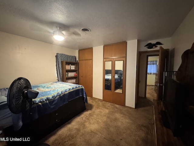 15708 Orleans Dr, Biloxi, MS 39532 - carpeted bedroom with multiple closets, a textured ceiling, and ceiling fan