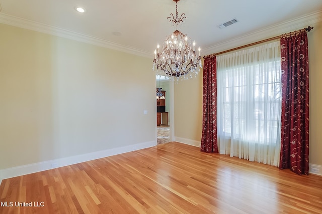 spare room with light hardwood / wood-style flooring, a notable chandelier, and ornamental molding