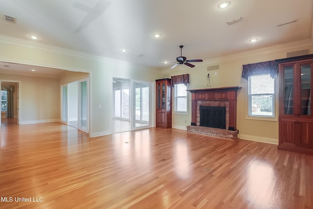 unfurnished living room featuring a fireplace, ceiling fan, light wood-type flooring, and ornamental molding