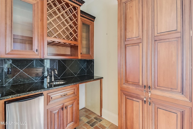 bar featuring tasteful backsplash, sink, dark stone counters, and stainless steel dishwasher