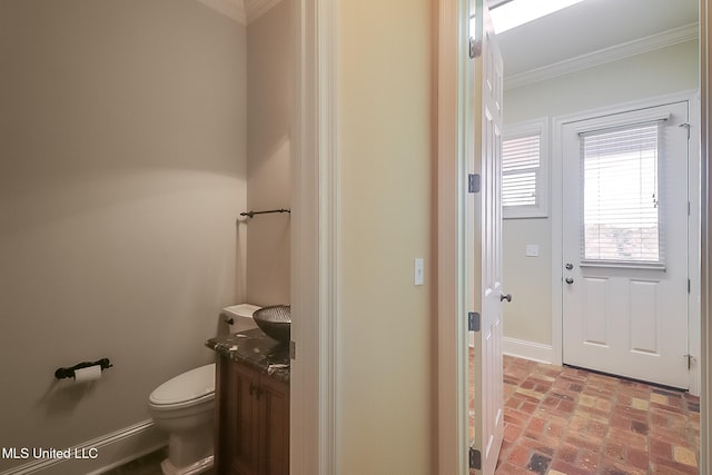 bathroom featuring vanity, toilet, and crown molding