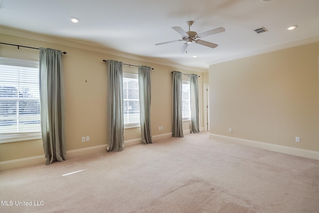 empty room with ceiling fan, light colored carpet, and crown molding