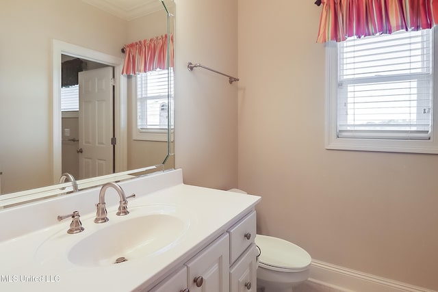 bathroom with vanity, toilet, and crown molding