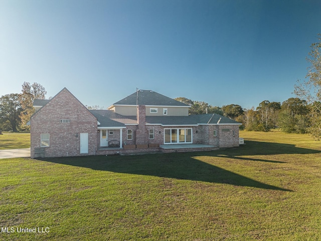 rear view of property with a yard and a patio