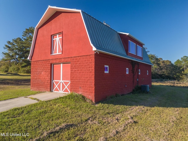 view of home's exterior with central air condition unit, an outdoor structure, and a lawn