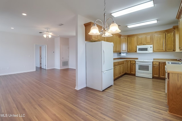 kitchen featuring white appliances, ceiling fan with notable chandelier, sink, light wood-type flooring, and decorative light fixtures