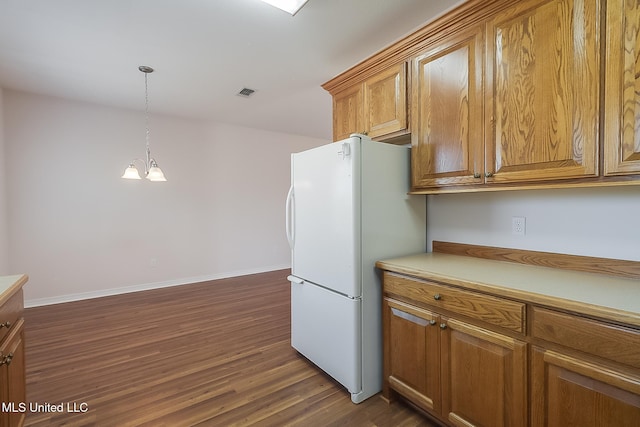 kitchen with a notable chandelier, dark hardwood / wood-style floors, white fridge, and decorative light fixtures