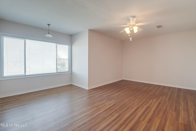 spare room featuring ceiling fan and dark wood-type flooring