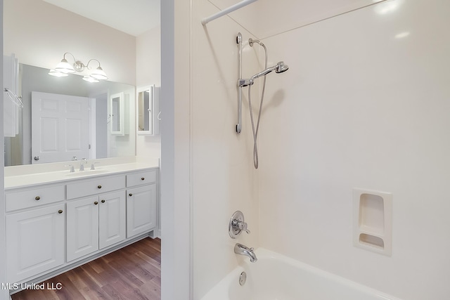 bathroom with hardwood / wood-style flooring, vanity, and tub / shower combination