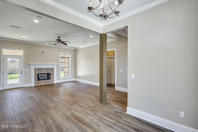 unfurnished living room featuring ornamental molding, a tile fireplace, wood finished floors, and baseboards