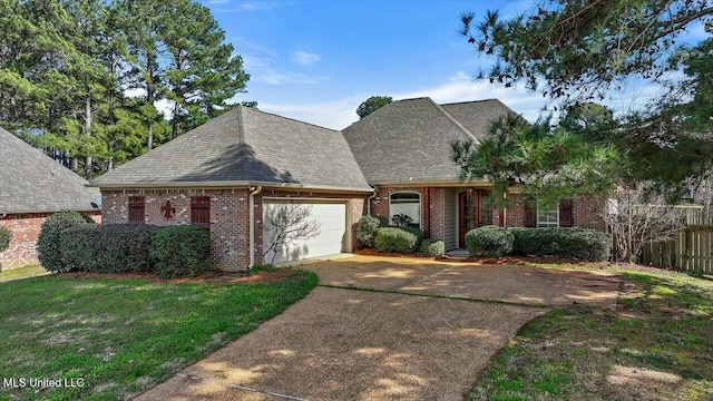 view of front facade with a garage, driveway, roof with shingles, a front lawn, and brick siding