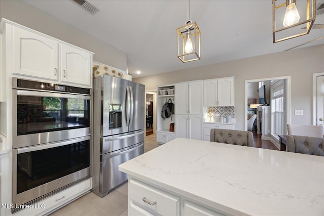 kitchen with white cabinetry, appliances with stainless steel finishes, and hanging light fixtures