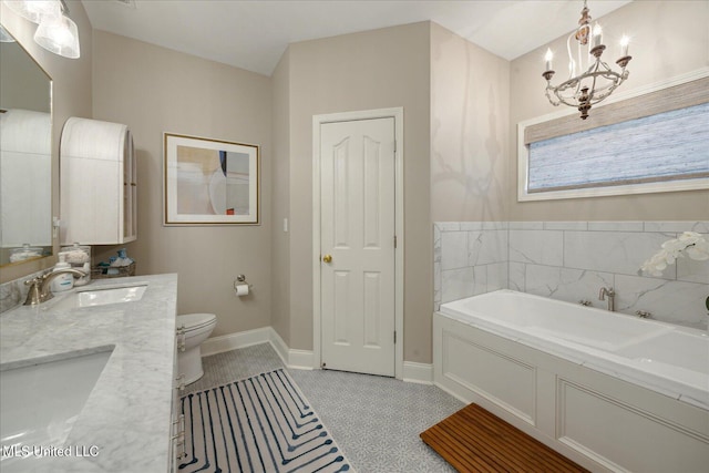 bathroom with a bathtub, vanity, toilet, and an inviting chandelier