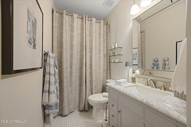 bathroom with tile patterned flooring, vanity, and toilet