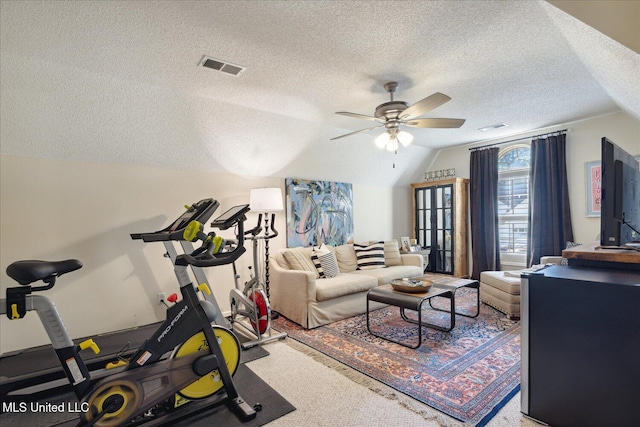 workout room featuring lofted ceiling, ceiling fan, a textured ceiling, and carpet floors