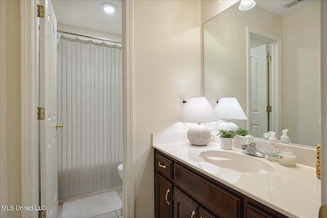 bathroom with toilet, vanity, tile patterned floors, and curtained shower