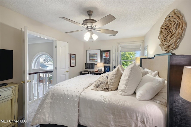 carpeted bedroom with multiple windows, a textured ceiling, ceiling fan, and access to exterior