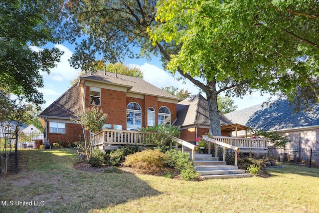 view of front facade featuring a wooden deck and a front yard