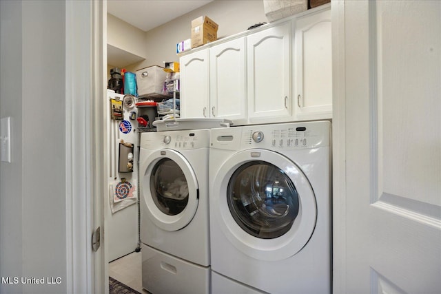 laundry area with washing machine and dryer and cabinets