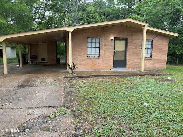 109 Miller St, Sidon, MS 38954 - view of front of home with concrete driveway, brick siding, a carport, and view of scattered trees