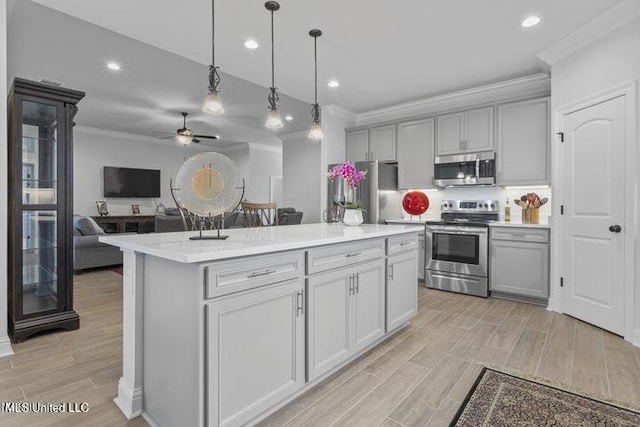 kitchen featuring appliances with stainless steel finishes, ornamental molding, wood finish floors, and gray cabinetry