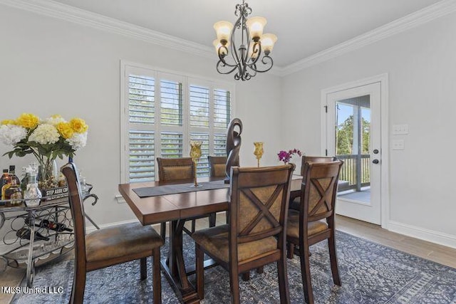 dining space featuring baseboards, an inviting chandelier, wood finished floors, and crown molding