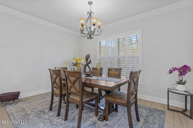 dining area featuring a chandelier, ornamental molding, wood finished floors, and baseboards