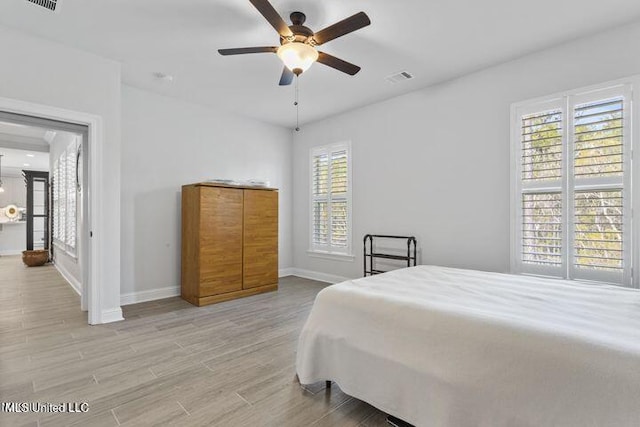 bedroom featuring light wood-type flooring, baseboards, visible vents, and ceiling fan